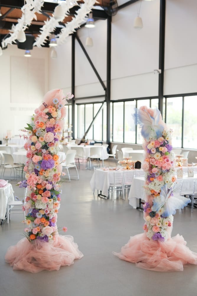 Enchanted Ball floral entrance pillars beside elegantly dressed tables